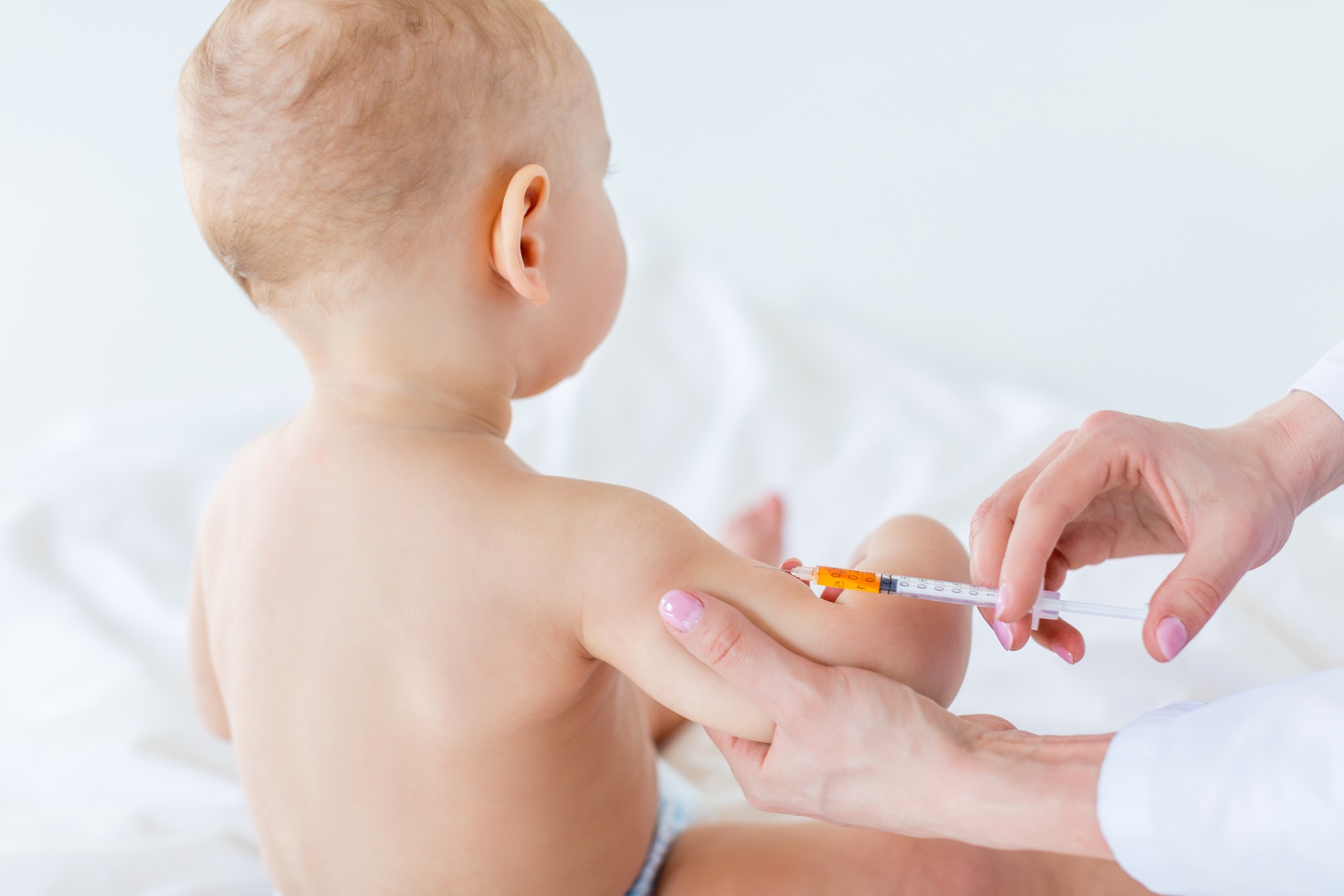 Cropped shot of medical worker making injection for cute baby boy, 1 year old baby concept