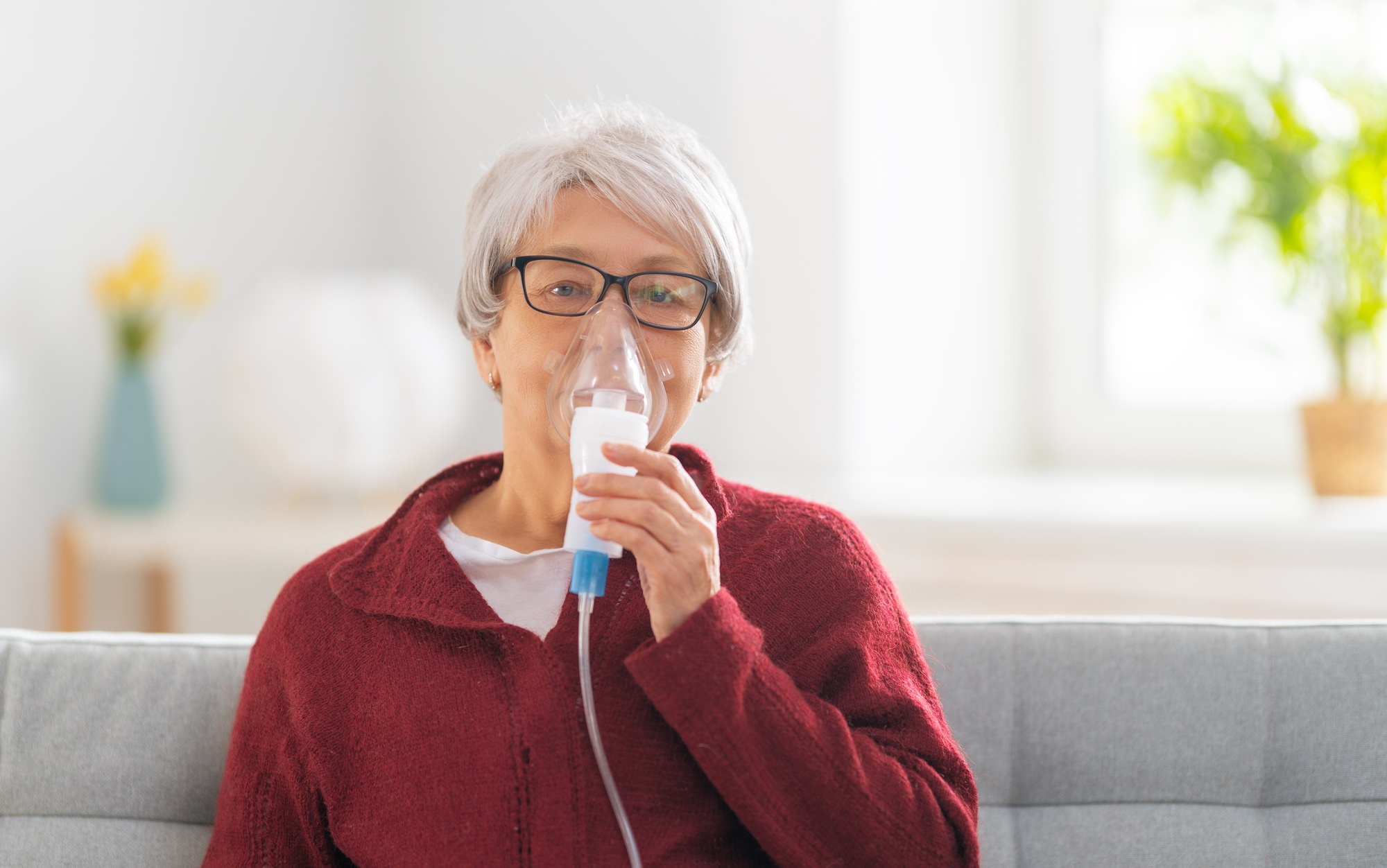 Elderly woman using inhaler for asthma